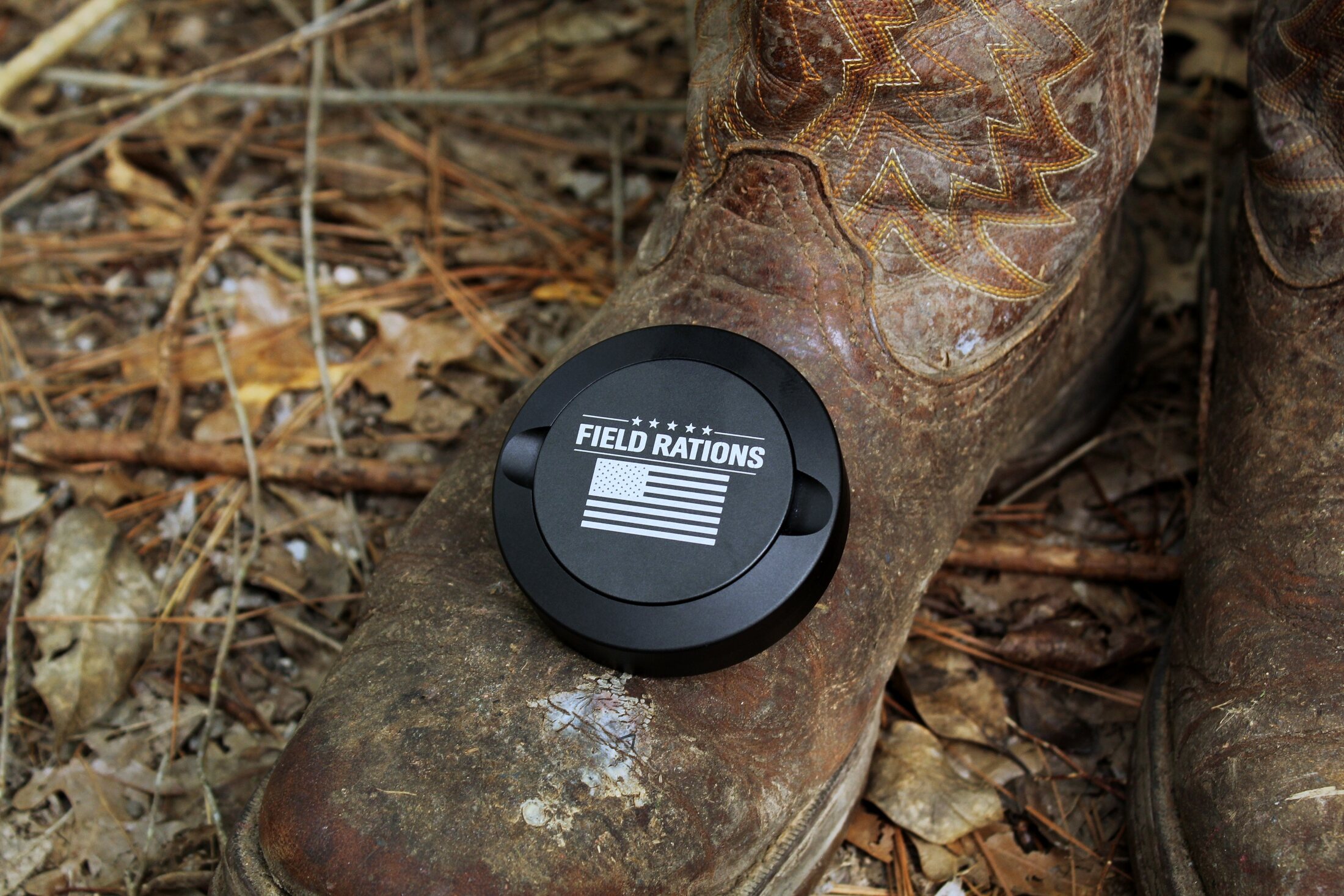 Black can resting on a cowboy boot